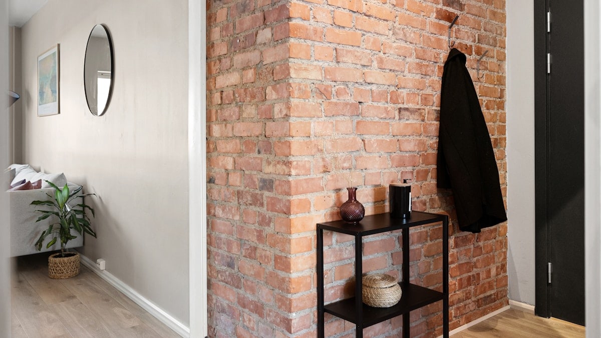 A room with a brick wall and a black door